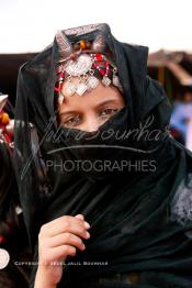 Image du Maroc Professionnelle de  Une jeune fille du désert pose en tenue traditionnelle durant le grand Moussem de Tan Tan. Ce grand rassemblement est organisé dans un site désertique sur lequel la ville de Tan Tan a toujours accueilli la majorité des tribus et des grandes familles nomades du désert lors d'un grand moussem, Samedi 18 septembre 2004. (Photo / Abdeljalil Bounhar)




